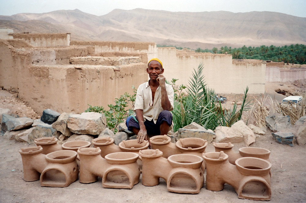A potter in southern Morocco displays the fuel-efficient cookstoves he learned how to make at NEF's Appropriate Technology Training Center. Ouarzazate, 1996.