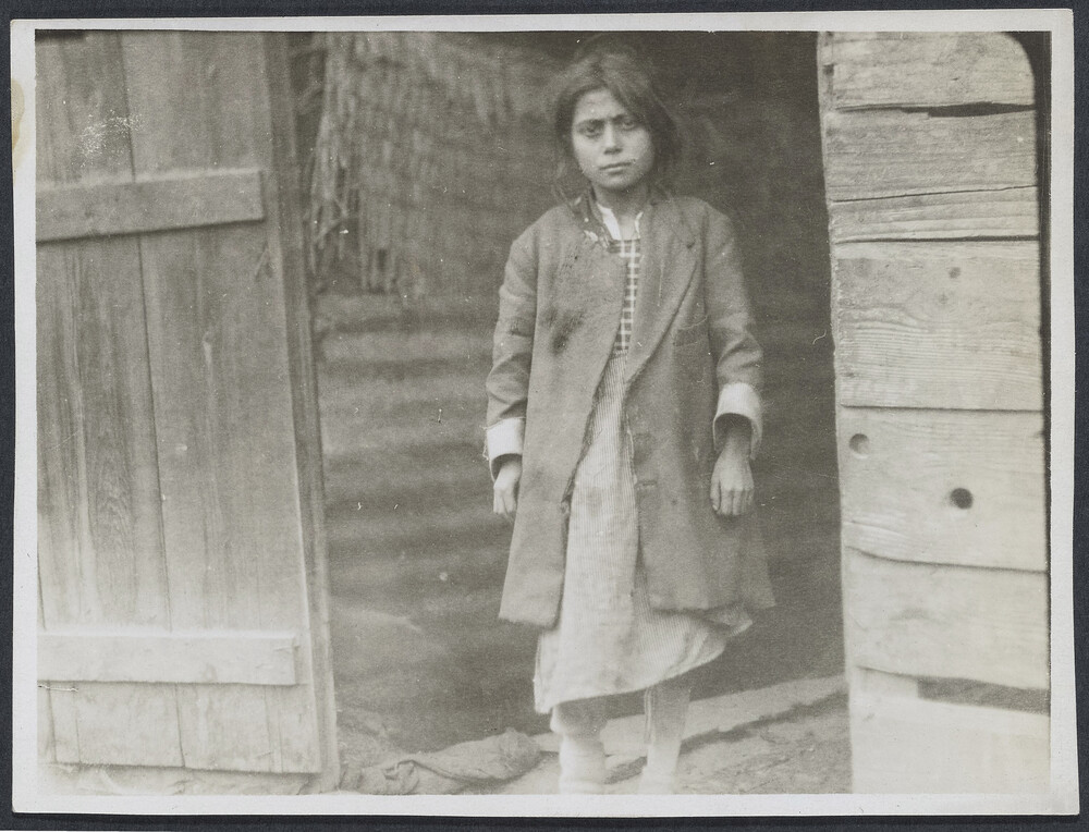 A girl stands at a wooden door. Alexandropol, c. 1923–1926.