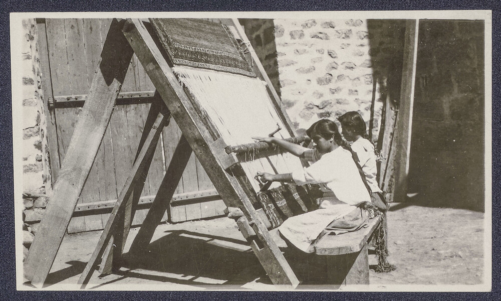 Two girls weave at an upright rug loom. Ghazir, c. 1925.
