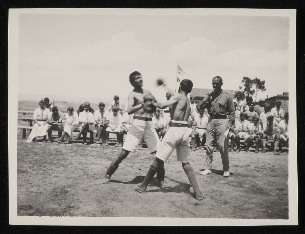Boys boxing before a referee, US flag, Caucasus, 1920s