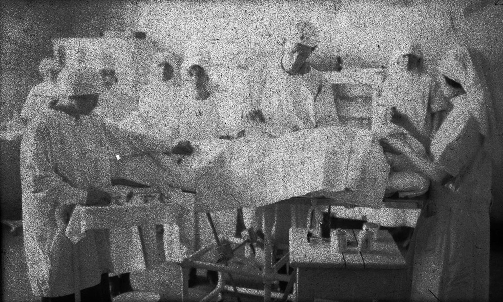 Medical staff attend a patient on an operating table.