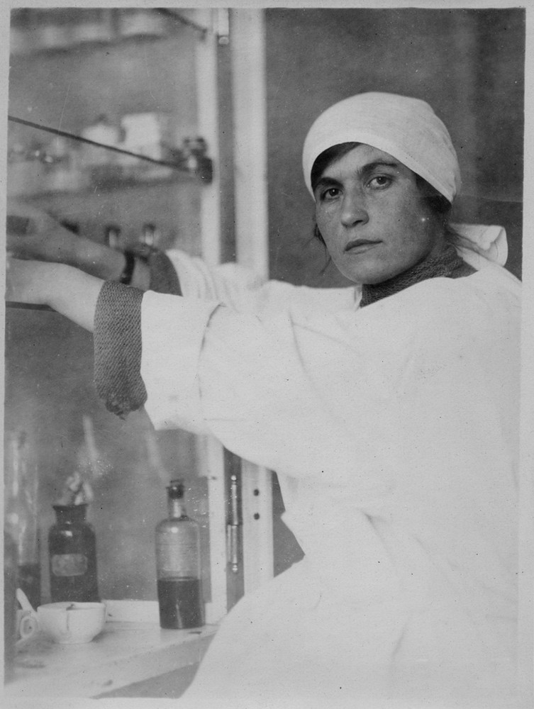 A nurse reaches into a medicine cupboard.