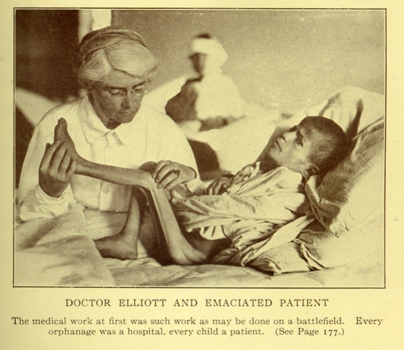 Dr. Mabel Elliott attends an emaciated child in bed, c. 1920.