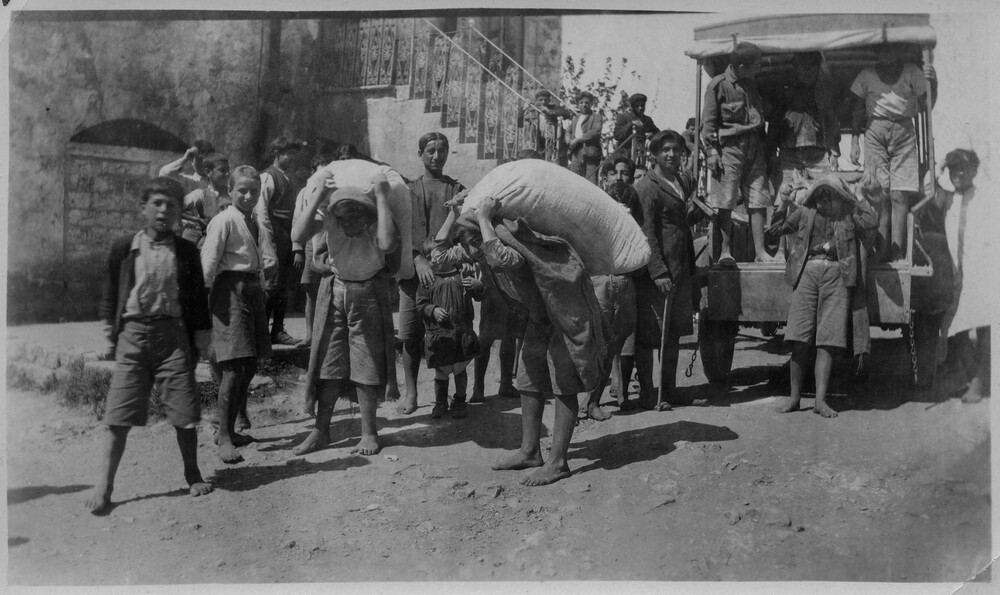 Orphan boys unload sacks of relief flour from a lorry at the Antilyas orphanage, north of Beirut, c. 1921–1923.