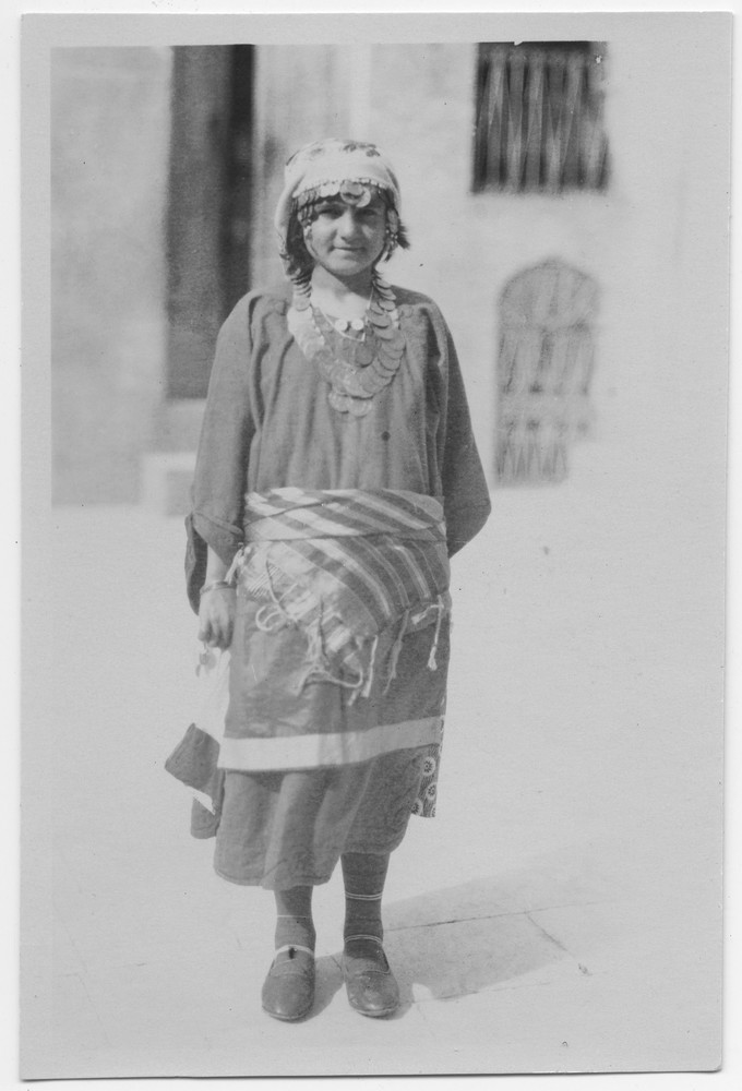 An Armenian woman who fled Turkey poses full-length in traditional coin-trimmed costume, Lebanon, c. 1921–1923.