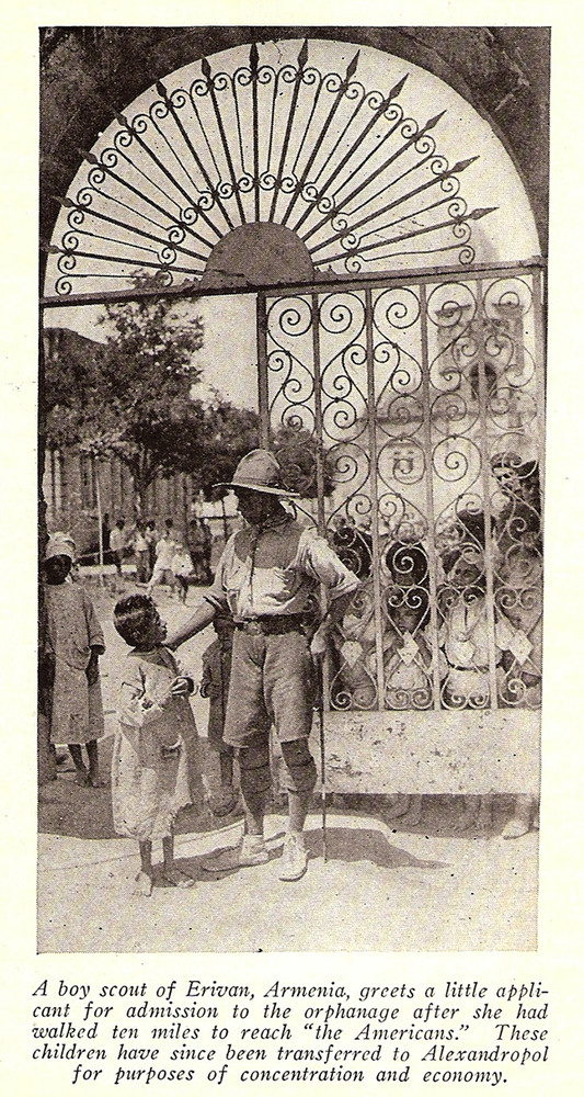 A Boy Scout greets a young applicant at the gates of the Near East Relief orphanage in Erivan (Yerevan), Armenia. The New Near East, October 1923. 