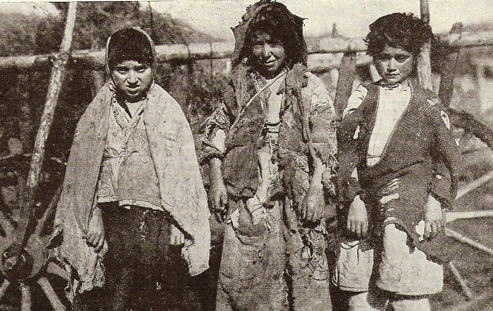 Three ragged children stand beside an oxcart at Karakilisa (Vanadzor), Armenia. The New Near East, April 1922.