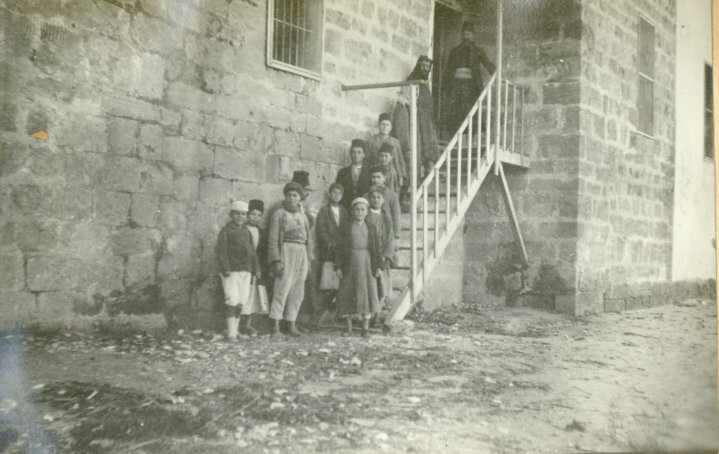 Children wait at the back door for clothing. Sidon, 1919–1920.