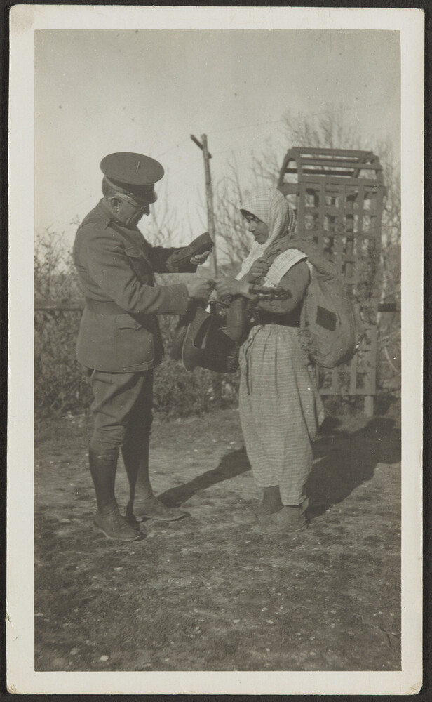 Dr. Wirt assisting Armenian woman carrying shoes, Marash
