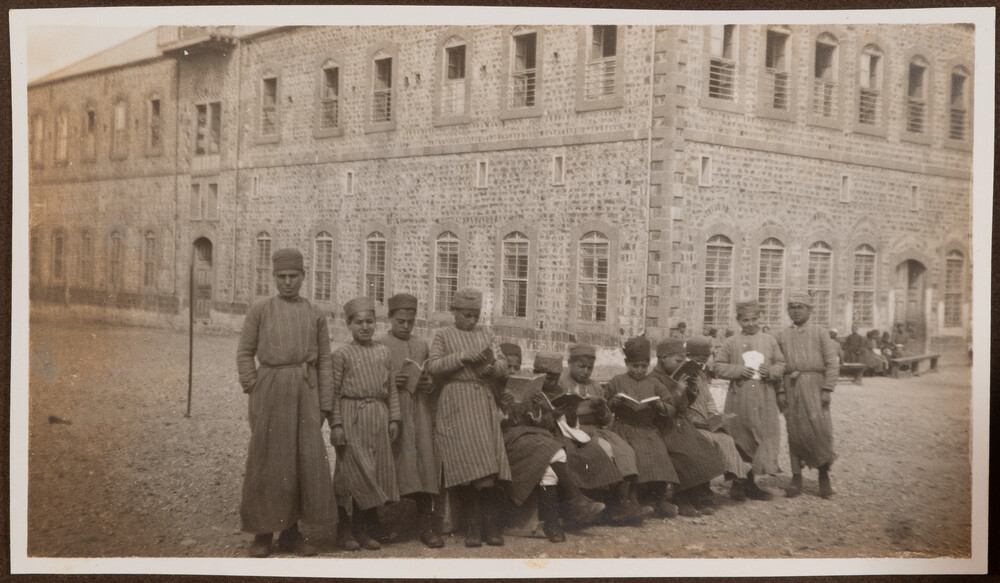 Boys read from books outside the orphanage. Homs, 1922.