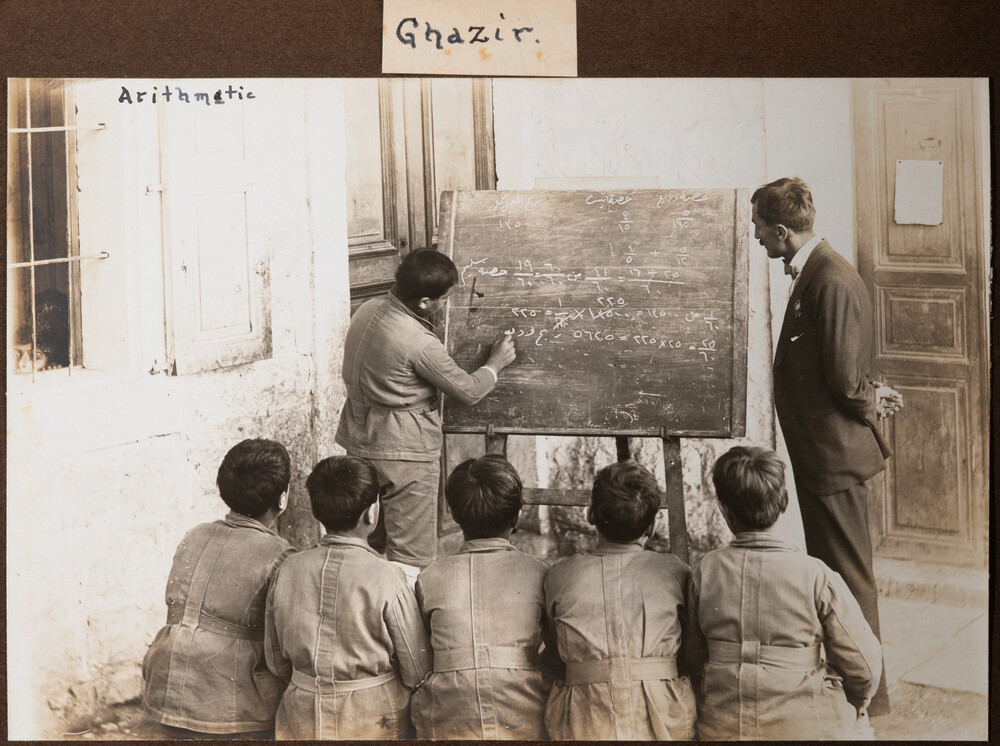 A boy works on arithmetic on the blackboard. Ghazir, 1922.