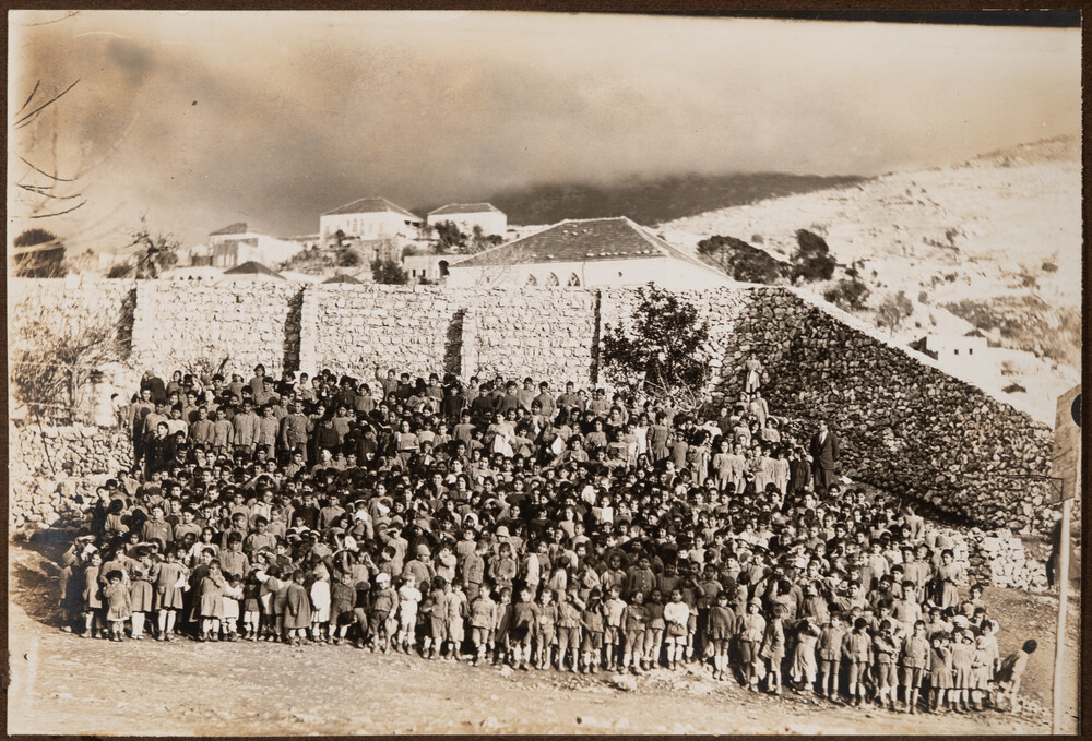 Hundreds of children assemble below the orphanage wall. Ghazir, 1922.