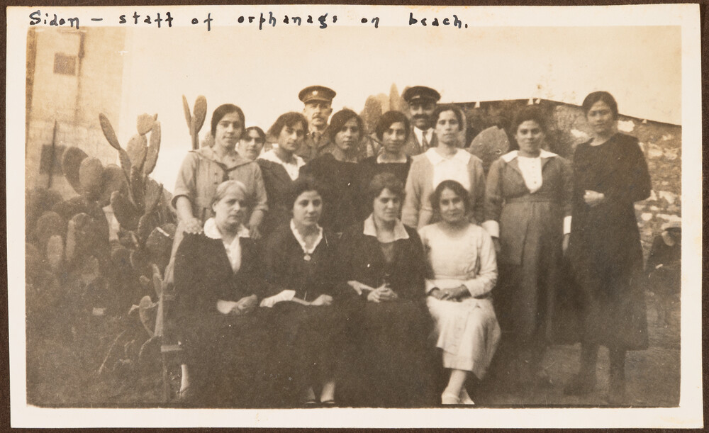 The beach orphanage staff pose by a cactus hedge. Sidon, 1922.